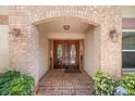 Close-up of the brick archway and decorative double front doors at 4868 Lake Valencia E Blvd, Palm Harbor, FL 34684