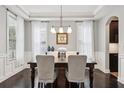 Elegant dining room featuring a coffered ceiling, hardwood floors, and a stylish chandelier at 5949 Parkset Dr, Lithia, FL 33547