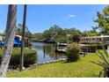 Waterfront property with dock, boat lift, and lush landscaping creating a serene and private backyard oasis at 624 Orange St, Palm Harbor, FL 34683