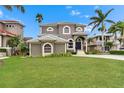 Charming two-story home with well-manicured lawn and lush landscaping creates an inviting curb appeal at 6301 Marbella Blvd, Apollo Beach, FL 33572