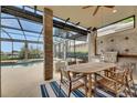 Outdoor living space with a built in grill, large table for dining, and a view of the beautiful pool at 6301 Marbella Blvd, Apollo Beach, FL 33572