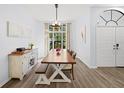 Bright dining room featuring a large window, wood floors, a long wooden table, and a stylish buffet at 772 Live Oak Ne Ter, St Petersburg, FL 33703