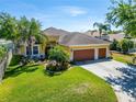 Beautifully landscaped front yard enhances this home's curb appeal, complete with a spacious driveway and a two-car garage at 9504 Laurel Ledge Dr, Riverview, FL 33569