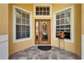 Close-up of the front door with decorative glass, flanked by windows, enhancing the home's curb appeal and entrance at 9504 Laurel Ledge Dr, Riverview, FL 33569