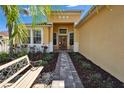 Inviting front entrance showcasing a beautifully landscaped walkway leading to a charming front door and a cozy bench at 9504 Laurel Ledge Dr, Riverview, FL 33569