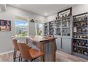 Custom-built bar with wood countertop, comfortable seating, and display shelves showcasing liquor collection and decor at 10814 Whitland Grove Dr, Riverview, FL 33578