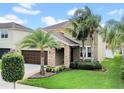 Beautiful two-story home featuring lush green lawn and mature palm trees at 11712 Winterset Cove Dr, Riverview, FL 33579