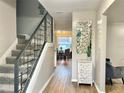 Hallway with staircase and decorative mirror, leading to the dining room and featuring wood-look flooring at 12432 81St Ct, Seminole, FL 33772