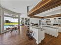 Open concept kitchen with wood beam, granite counters, stainless appliances, island seating and pool views at 1292 Myers Rd, Brooksville, FL 34602