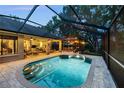 Enjoy this beautiful pool area with brick pavers, screened enclosure, and outdoor seating, perfect for evening relaxation at 13806 Sumac Pl, Tampa, FL 33625