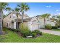 Two-story home featuring a two-car garage, well-manicured landscaping, and a brick-paved driveway at 16030 Bella Woods Dr, Tampa, FL 33647