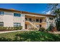 Condominium exterior featuring two stories, garden landscaping, stairway, and covered walkways at 1686 Seascape Cir, Tarpon Springs, FL 34689