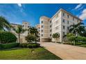 Luxury condominium exterior featuring lush landscaping, palms, red tiled roof, and a private entrance at 1860 N Fort Harrison Ave # 106, Clearwater, FL 33755