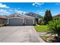 Charming gray home featuring a spacious three-car garage and well-maintained landscaping at 19750 Ellendale Dr, Land O Lakes, FL 34638
