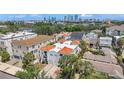Aerial view of a condo with a red tiled roof, balconies, palm trees, and a city skyline at 406 S Melville Ave # 1, Tampa, FL 33606