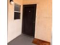 Condo front door and small window with brown trim and concrete floor at 5557 Sea Forest Dr # 216, New Port Richey, FL 34652