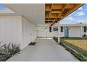 Inviting carport leading to the home's entrance with a bright blue door and well-maintained landscaping at 5805 S Hubert Ave, Tampa, FL 33616