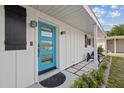 Close up of the home's charming blue front door with modern fixtures and neat landscaping at 5805 S Hubert Ave, Tampa, FL 33616