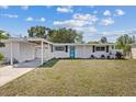 Charming single-story home featuring a covered carport, blue entry door, and tidy front yard at 5805 S Hubert Ave, Tampa, FL 33616