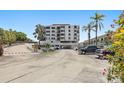 Exterior view of condo building and parking lot surrounded by palm trees at 6361 Bahia Del Mar Blvd # 205, St Petersburg, FL 33715