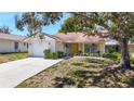 A single-story home boasts an attached garage, yellow door, and a landscaped front yard at 10819 Los Santos Dr, Port Richey, FL 34668