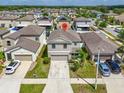 Birds-eye view of gray two-story house, green lawn, and concrete driveway in Gathering-friendly neighborhood at 14812 Boulder Pass Pl, Wimauma, FL 33598