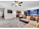 Open-concept living room flows into the kitchen, with tiled floors and a large sectional couch at 14812 Boulder Pass Pl, Wimauma, FL 33598