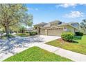 Exterior of a well-landscaped house with a spacious driveway and lush green lawn on a sunny day at 15714 Ibisridge Dr, Lithia, FL 33547
