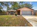 A single-story home with a spacious driveway, a lush lawn, and mature trees in a Gathering-friendly neighborhood at 16039 Frost Dr, Hudson, FL 34667