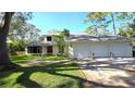 Inviting two-story home featuring a three-car garage and well-maintained landscaping at 1800 Salem Ct, Dunedin, FL 34698