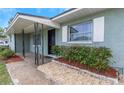 Inviting home entrance with a covered porch, rock landscaping, and a dark front door at 1881 Stancel Dr, Clearwater, FL 33764