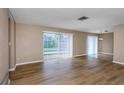 Bright living room with hardwood floors and sliding glass doors leading to the pool at 1881 Stancel Dr, Clearwater, FL 33764