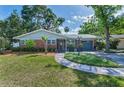 Charming brick home featuring manicured lawn, sidewalk, and meticulous landscaping creates a welcoming curb appeal at 202 S Hesperides St, Tampa, FL 33609