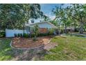 Side view of home featuring landscaped yard and fencing at 202 S Hesperides St, Tampa, FL 33609