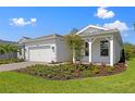 Beautiful single Gathering home exterior showcasing well-manicured lawn and neutral-colored facade at 29156 Coral Harbour Dr, Englewood, FL 34223