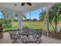 Screened patio with outdoor seating, perfect for enjoying the expansive backyard view at 3009 Banyan Hill Ln, Land O Lakes, FL 34639