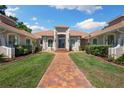 Inviting front entrance with brick walkway, manicured lawn, and a charming double door at 30723 Reed Rd, Dade City, FL 33523