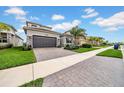 Charming home featuring stone accents, well-maintained landscaping, and a brick-paved driveway at 3096 Great Banyan Way, Wesley Chapel, FL 33543