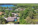 Picturesque aerial view of a residential neighborhood with pools, mature trees, and a serene lake nearby at 3212 Sunset Lakes Blvd, Land O Lakes, FL 34638