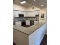 Bright kitchen featuring stainless steel appliances, granite countertops, and white cabinets at 402 S Armenia Ave # 127, Tampa, FL 33609