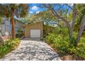 Charming home with a long driveway, attached garage, and mature landscaping at 407 Indiana Ave, Crystal Beach, FL 34681