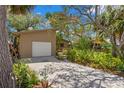 Inviting home with mature landscaping, a large driveway, and an attached garage at 407 Indiana Ave, Crystal Beach, FL 34681