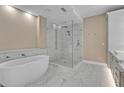 Luxurious bathroom featuring a soaking tub and glass enclosed shower with marble tile at 455 Pinellas Bayway S # 3B, Tierra Verde, FL 33715