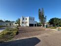 Modern two-story home with a white exterior, black garage doors, and a newly landscaped front yard at 4716 W Lawn Ave, Tampa, FL 33611
