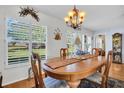 Bright dining room with large windows and a charming chandelier, perfect for Gathering meals at 4819 Boonesboro Ct, New Port Richey, FL 34655
