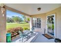 Inviting covered porch with seating, a welcome mat, and view of lush green lawn and landscaping at 4819 Boonesboro Ct, New Port Richey, FL 34655