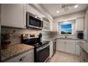 Updated kitchen with stainless steel appliances, granite countertops, and white cabinetry at 5575 Gulf Blvd # 329, St Pete Beach, FL 33706