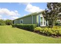 Well-maintained exterior featuring neat landscaping, healthy hedges, and an expansive green lawn at 6417 Blue Sail Ln, Apollo Beach, FL 33572