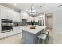 Modern kitchen featuring stainless steel appliances, marble countertops, large center island, and ample cabinet space at 716 Manns Harbor Dr, Apollo Beach, FL 33572