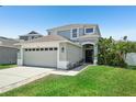 Inviting two-story home boasts a two-car garage, lush lawn, and a welcoming front entrance at 7207 Forest Mere Dr, Riverview, FL 33578
